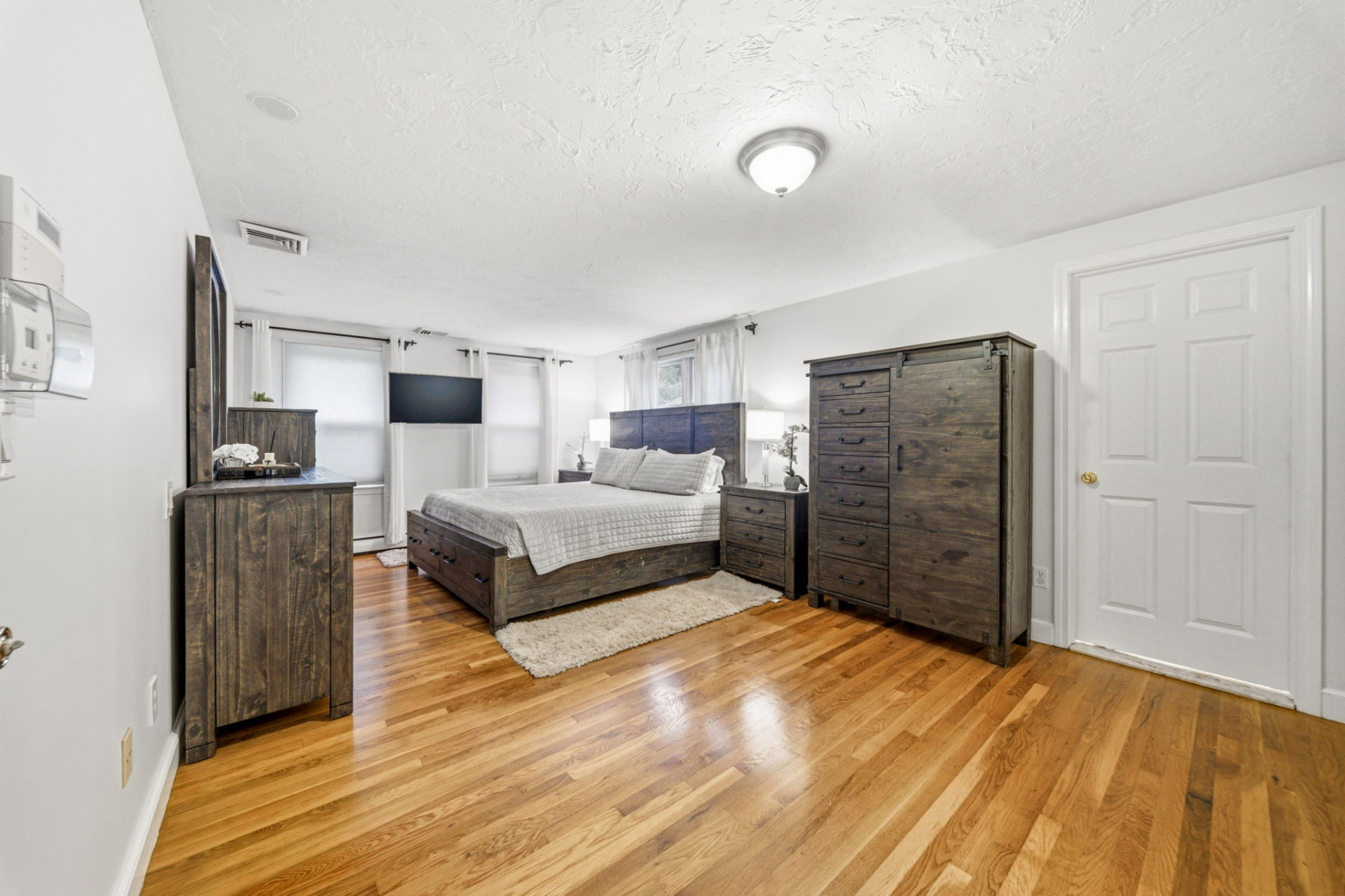 Primary bedroom with hardwood floors and generous closet space