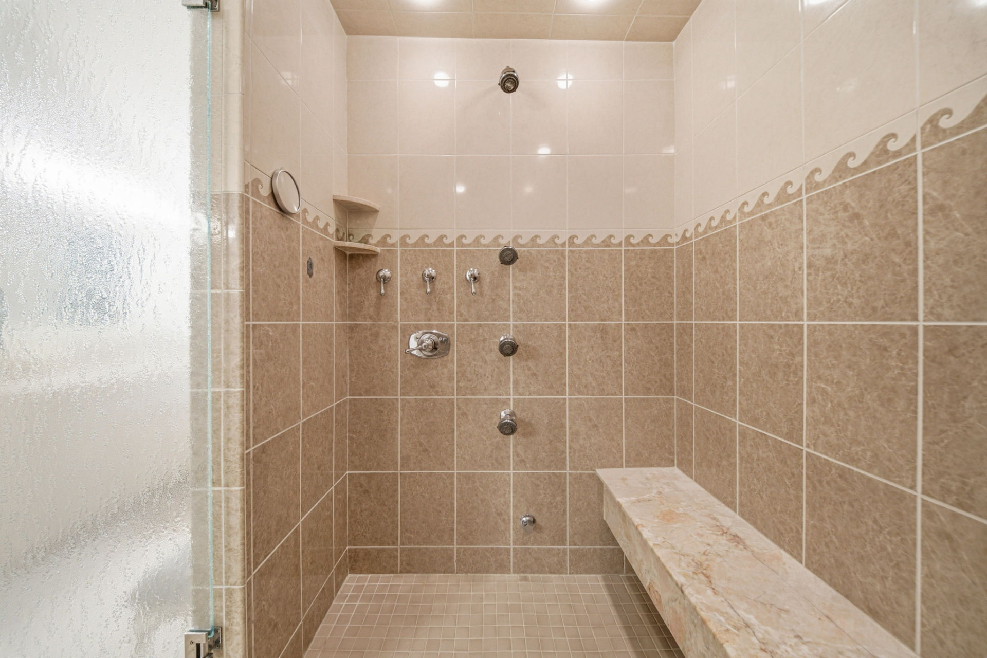 Walk-in spa shower with rainhead, body jets and stone bench